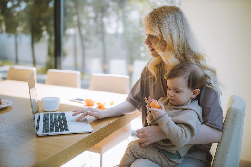 Woman at table with laptop and baby